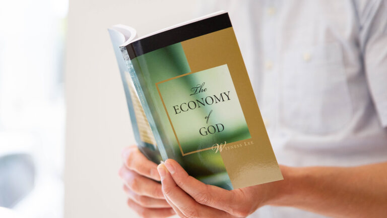man readying "the economy of God" book